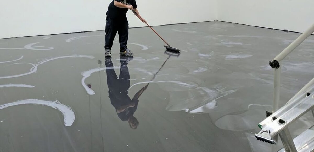 Installer applying metallic epoxy coating during installation
